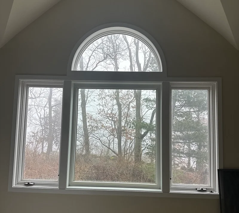 Triple casement window with a round top above